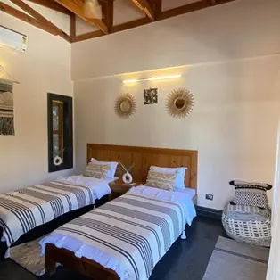 Twin Shared Accommodation at Abhayaranya Yoga Ashram, Rishikesh Comfortable twin shared room at Abhayaranya Yoga Ashram in Rishikesh, designed for peaceful living with serene surroundings and essential amenities for yoga practitioners.
